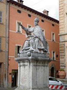 una estatua de un hombre parado frente a un edificio en B&B Piazza del Papa, en SantʼAngelo in Vado