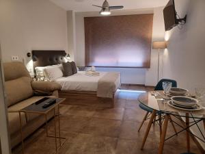 ein Wohnzimmer mit einem Bett, einem Sofa und einem Tisch in der Unterkunft Apartamento Luxury Triana-Los Remedios in Sevilla