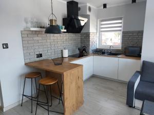 a kitchen with a wooden table and stools at Dream Apart in Szklarska Poręba