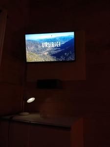 een flatscreen-tv aan een muur in een donkere kamer bij Quinta dos Ventos Chalé in Urubici