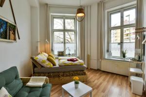 a living room with a couch and two windows at Kiez Hostel Berlin in Berlin