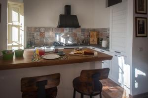 een keuken met een aanrecht en 2 barkrukken bij il Rifugio dell'Artista in Passignano sul Trasimeno