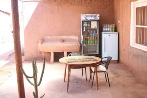 a table and chairs in a room with a refrigerator at Quinta Adela Bed & Breakfast in San Pedro de Atacama