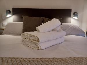 einen Stapel Handtücher auf dem Bett in der Unterkunft Apartamento Luxury Triana-Los Remedios in Sevilla