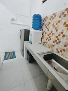 a kitchen with a sink and a counter top at Dnaiko Syariah Hotel in Bukittinggi