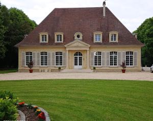una casa grande con un gran césped delante de ella en chambre SIXTIES en Lingèvres