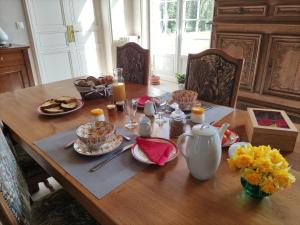una mesa de madera con un plato de comida. en chambre SIXTIES en Lingèvres