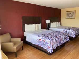 una habitación de hotel con dos camas y una silla en Red Roof Inn & Suites Cleveland, TN, en Cleveland