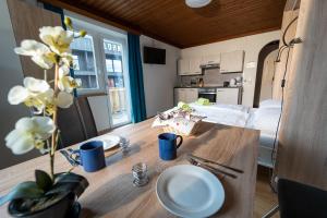 uma mesa de madeira com pratos e flores em Alpin Apartments em Maria Alm am Steinernen Meer