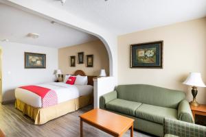 une chambre d'hôtel avec un lit et un canapé dans l'établissement OYO Hotel Stafford TX I-69 North, à Stafford