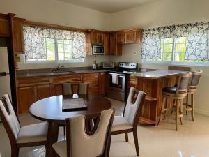 a kitchen with wooden cabinets and a table and chairs at Westmore Beach Villas Limited in Whitehouse