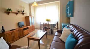 ein Wohnzimmer mit einem Sofa und einem Tisch in der Unterkunft Apartamento con vistas al mar en Carril in Vilagarcia de Arousa