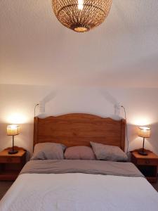 um quarto com uma cama com 2 candeeiros nas mesas em T2/3 6pers & pied des pistes & piscine chauffée em Vars