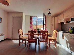 a kitchen with a dining room table and chairs at T2/3 6pers & pied des pistes & piscine chauffée in Vars