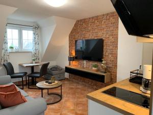 a living room with a tv and a brick wall at Frische Brise in Insel Poel