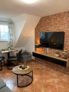 a living room with a brick wall with a large television at Frische Brise in Insel Poel