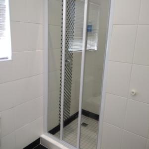 una doccia con porta in vetro in bagno di Birds Holiday Accommodation 2 a Città del Capo