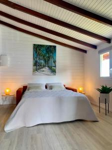 um quarto com uma grande cama branca em um quarto em SOMPTUEUX DUPLEX SUR LA ROUTE DES PLAGES em Sainte-Anne