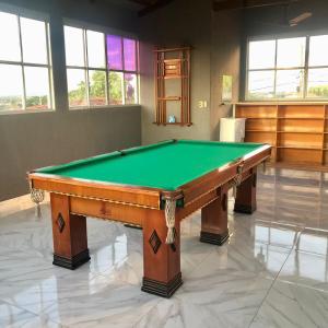 a pool table in a room with a green at Casa 3/4 com piscina e mesa de sinuca em Caldas Novas in Caldas Novas