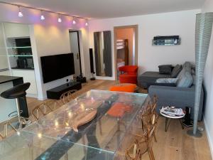a living room with a glass table and a couch at Appartement design en plein centre du Touquet in Le Touquet-Paris-Plage
