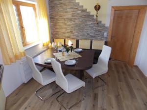 uma sala de jantar com uma mesa e cadeiras brancas em Ferienwohnung Eberharter em Rohrberg