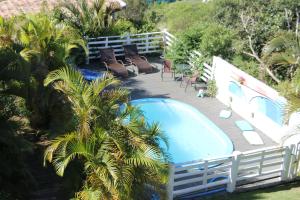 a deck with chairs and a swimming pool at Pousada Sonho do Vale in Praia do Rosa
