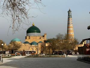 a large building with a tower and a mosque at XIVA AZIM OTA in Khiva