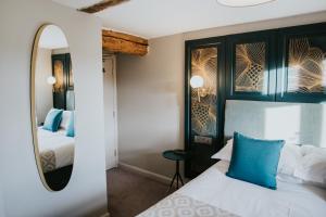 a bedroom with a bed and a mirror at Furzeleigh Mill in Buckfastleigh