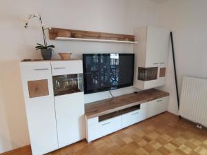 a white entertainment center with a flat screen tv at Apartma Rožmarin Bohinj in Bohinj