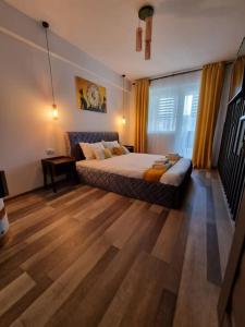 sypialnia z łóżkiem i drewnianą podłogą w obiekcie Luxury Apartments w mieście Bacău