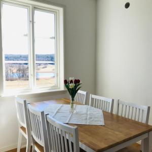 a dining room table with a vase of flowers on it at Kastellegården Skanskullen in Kungälv