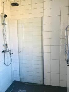 a bathroom with a shower with white tiled walls at Kastellegården Skanskullen in Kungälv
