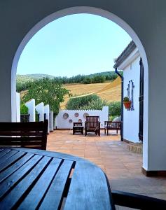 a patio with an archway with benches and a table at Casa Moya in Alcalá la Real
