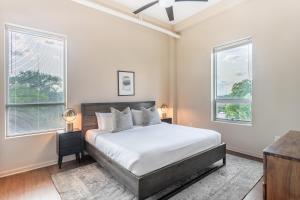 a white bedroom with a bed and two windows at Mint House Greenville - West End in Greenville