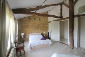 a bedroom with a bed and a stone wall at La Villa a Bel-Endroit in Marciac
