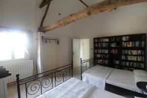 a bedroom with two beds and a book shelf at La Villa a Bel-Endroit in Marciac