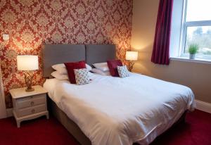 a bedroom with a large white bed with two lamps at Duchy House Bed and Breakfast in Princetown