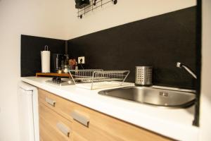 a kitchen with a sink and a black wall at Rooms & Apartments La Casa di Loreto in Rovinj +37 photos