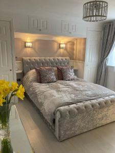 a bedroom with a large bed with a couch at Hideaway at Botany Bay in Broadstairs