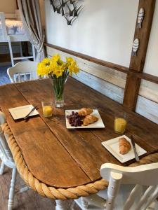 a wooden table with a plate of food on it at Hideaway at Botany Bay in Broadstairs