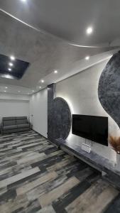 sala de estar con TV de pantalla plana en la pared en La casa di SELLY - A Due Metri Dal Mare-, en Bergeggi