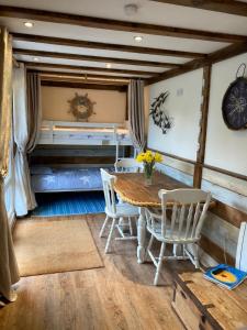 ein Esszimmer mit einem Holztisch und Stühlen in der Unterkunft Hideaway at Botany Bay in Broadstairs