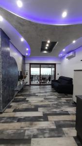 una sala de estar con luces moradas en el techo en La casa di SELLY - A Due Metri Dal Mare-, en Bergeggi