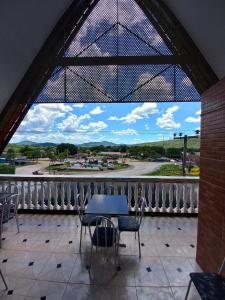 a balcony with a table and chairs and a view of a street at Pousada Adorno in Colinas Do Sul