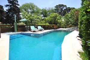 einen Pool mit 2 Stühlen und einem Sonnenschirm in der Unterkunft Apart Octogono Condominio in Villa Gesell