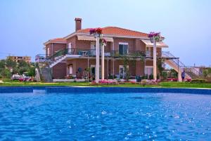 a house with a swimming pool in front of it at Kiki's Place in Nikiti