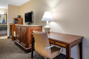 a hotel room with a desk and a television at Quality Inn Kennedy Space Center in Titusville
