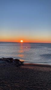 una puesta de sol en la playa con la puesta de sol sobre el océano en La casa di SELLY - A Due Metri Dal Mare-, en Bergeggi