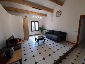 a living room with a couch and a clock on the wall at Maison chaleureuse in Rustrel