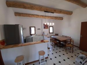 een keuken en eetkamer met een tafel en stoelen bij Maison chaleureuse in Rustrel